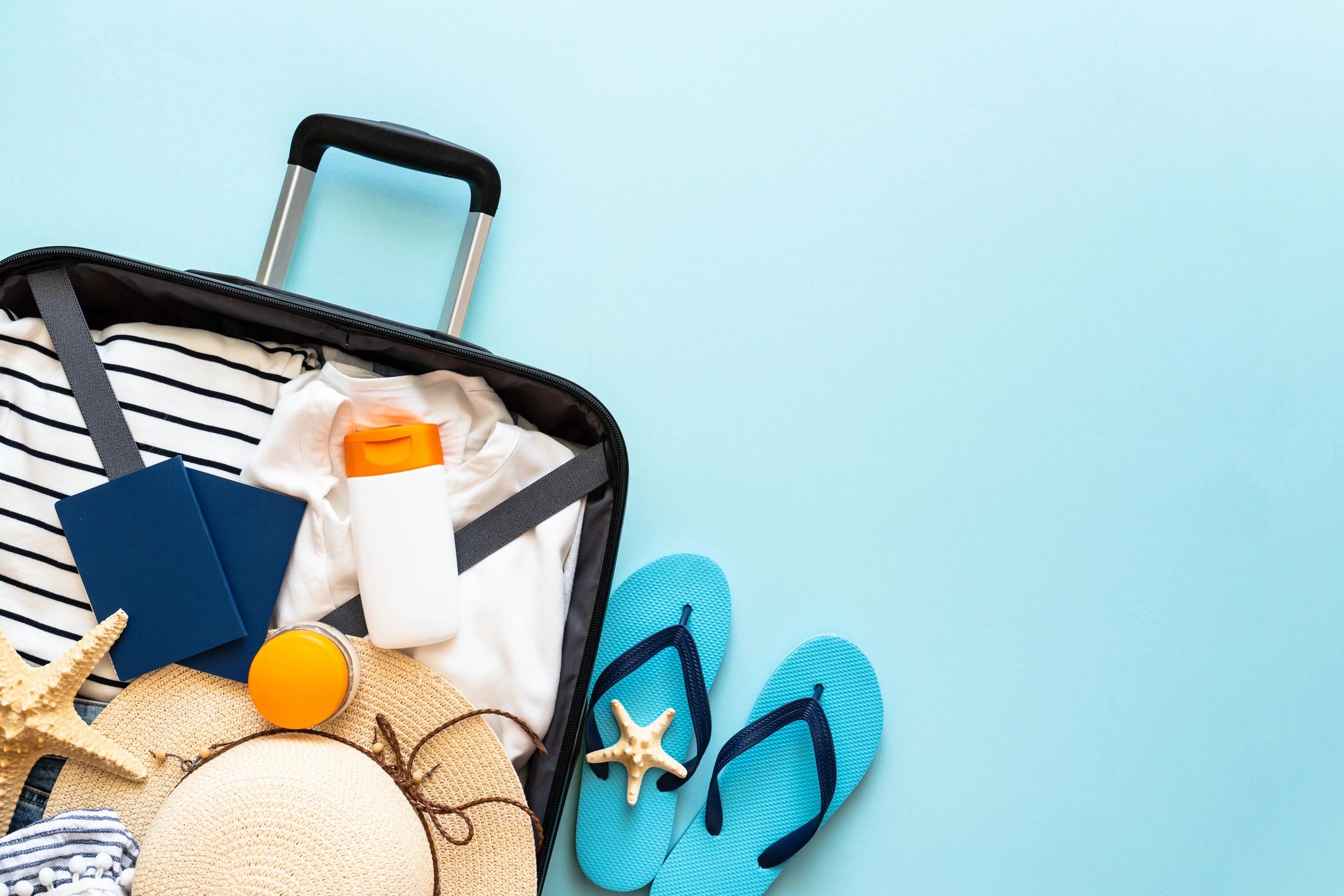 Open suitcase with travel essentials arranged for a weekend getaway