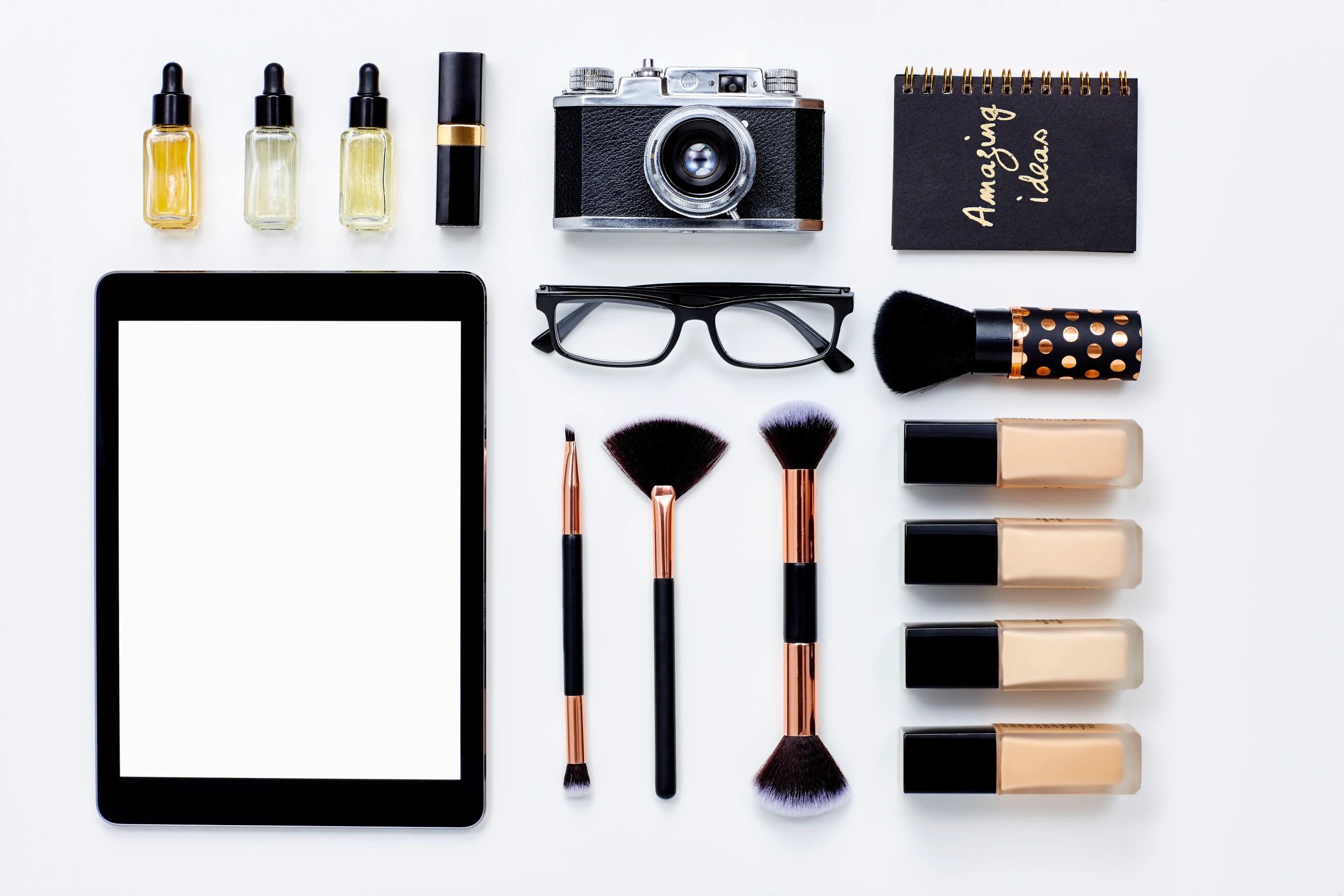 Editorial flat lay with tablet and accessories on a light background